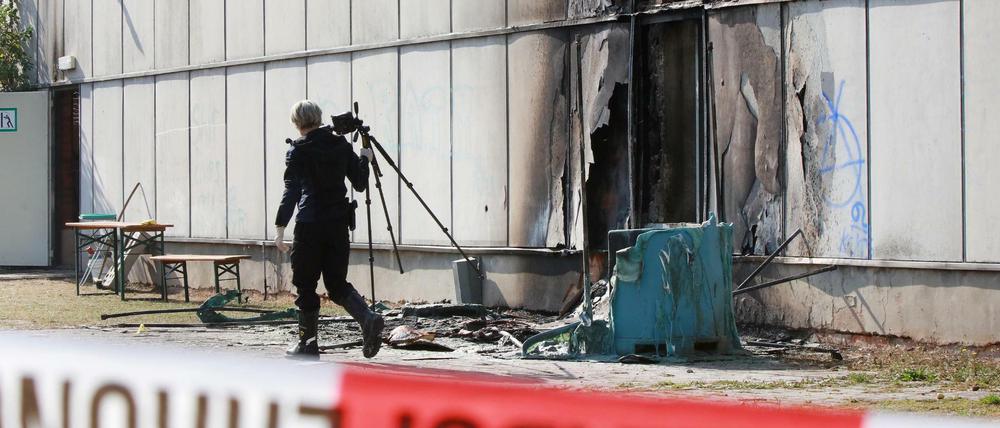 Eine Kriminalpolizistin untersucht am Sonntag in Friemar (Thüringen) nach einem Feuer in einer Notunterkunft für Flüchtlinge den Brandort. Nach Angaben der Polizei brach das Feuer am frühen Sonntagmorgen an mobilen Toiletten aus.