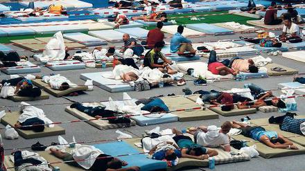 Flüchtlinge in einer Turnhalle. Die Enge macht aggressiv. Foto: Peter Kneffel/dpa