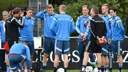 Assistenztrainer Thomas Schneider (l) und Torwarttrainer Andreas Koepke (3.v.r) haben die Nationalspieler Marco Reus (l-r), Max Kruse, Matthias Ginter, Andre Schuerrle, Marc-Andre ter Stegen, Kevin Volland, Bernd Leno und Sebastian Rudy um sich versammelt. 