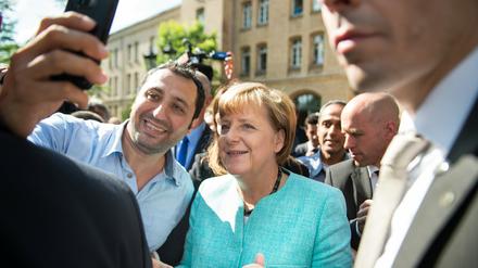 Angela Merkel posiert vor einer Berliner Schule mit einem Flüchtling für ein Selfie. CDU-Funktionäre aus acht Bundesländern kritisieren die Bundeskanzlerin für ihre Flüchtlingspolitik. 