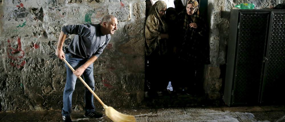 Ein Mann reinigt in der Jerusalemer Altstadt den Ort, an dem am Mittwoch eine palästinensische Frau einen Israeli mit einem Messer attackiert hat. Der Angegriffene schoss daraufhin auf die Täterin und verletzte sie schwer.
