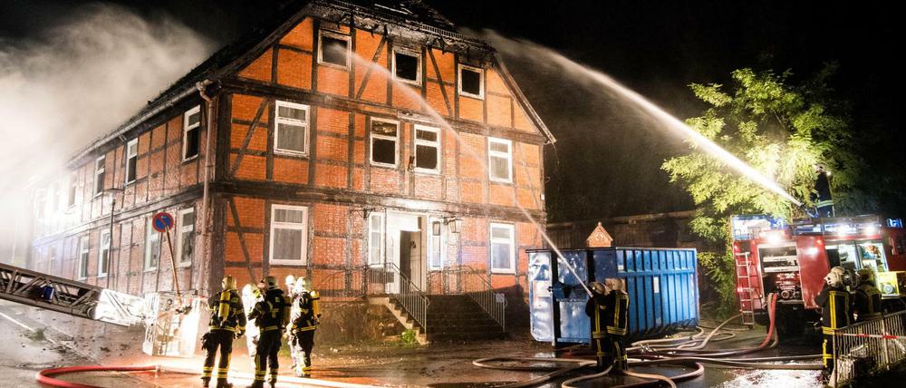 Feuerwehrleute löschen am späten Sonntagabend in Boizenburg an der Elbe (Mecklenburg-Vorpommern) eine brennende geplante Notunterkunft für Flüchtlinge. 