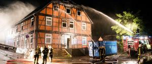 Feuerwehrleute löschen am späten Sonntagabend in Boizenburg an der Elbe (Mecklenburg-Vorpommern) eine brennende geplante Notunterkunft für Flüchtlinge.