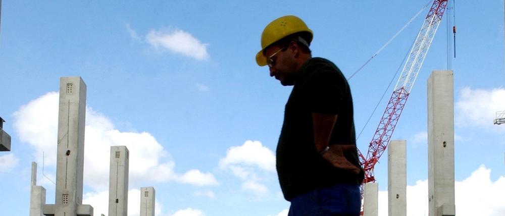 Ein Arbeiter geht am Mittwoch (01.10.2003) durch einen Pfütze im Rohbau der Chipfabrik in Frankfurt (Oder). 