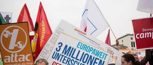 Verschiedene Aktionsbündnisse stehen mit Fahnen und Transparenten vor dem Brandenburger Tor in Berlin, um für eine geplante Großdemonstration am 10.10.2015 gegen die Handelsabkommen TTIP und CETA zu werben. 