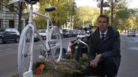 Heinrich Strößenreuther mit dem Mahnfahrrad auf dem Mittelstreifen der Turmstraße. Im Amtsgericht Tiergarten auf der rechten Straßenseite wurde das kritisierte Urteil gefällt.