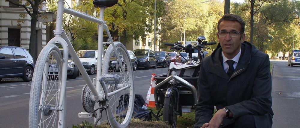 Heinrich Strößenreuther mit dem Mahnfahrrad auf dem Mittelstreifen der Turmstraße. Im Amtsgericht Tiergarten auf der rechten Straßenseite wurde das kritisierte Urteil gefällt.