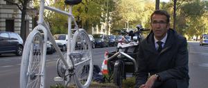 Heinrich Strößenreuther mit dem Mahnfahrrad auf dem Mittelstreifen der Turmstraße. Im Amtsgericht Tiergarten auf der rechten Straßenseite wurde das kritisierte Urteil gefällt.