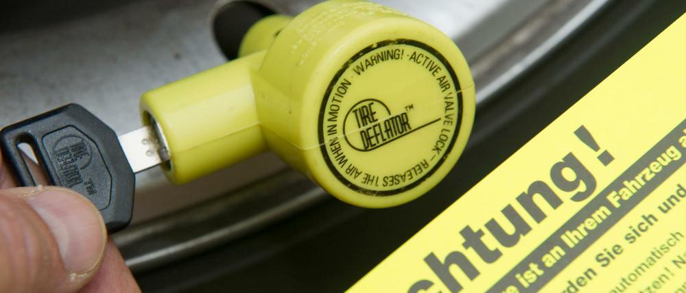 Ventilwächter werden am Autoreifen angebracht und mit einem Schloss gesichert. Wer trotzdem losfährt, muss mit einem platten Reifen rechnen.
