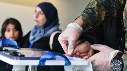 Dem Vater einer Flüchtlingsfamilie aus dem syrischen Aleppo werden im Registrierungszentrum einer Flüchtlingsunterkunft in Heidelberg Fingerabdrücke abgenommen. Mit Hilfe des Registrierungszentrums sollen Asylanträge schneller abgewickelt werden.