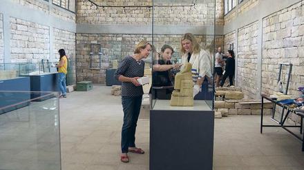 Das Bild zeigt einen Ausstellungsraum mit Glasvitrinen und Besuchern.