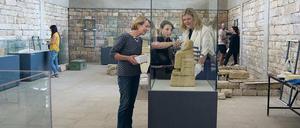 Das Bild zeigt einen Ausstellungsraum mit Glasvitrinen und Besuchern.