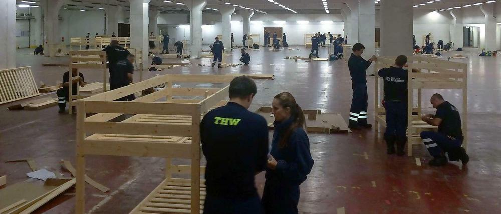 Helfer von Feuerwehr und THW bauen die Betten auf. 