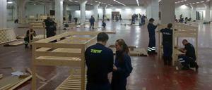 Helfer von Feuerwehr und THW bauen die Betten auf.