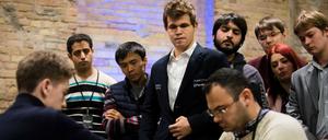 Schachweltmeister Magnus Carlsen (Mitte) beobachtet bei der Blitzschach-Weltmeisterschaft in Berlin eine Schachpartie.