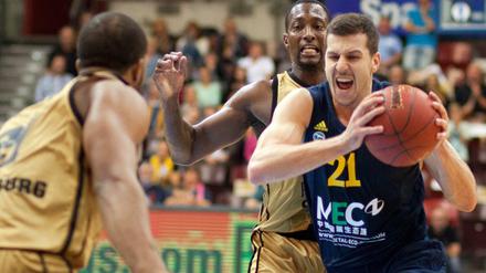 Alba Berlins Dragan Milosavljevic (r) versucht sich gegen Ludwigsburgs Rocky Trice (M.) durchzusetzen.