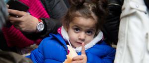 Die zweijährige Mini aus Syrien steht am 19.10.2015 in Berlin in einer Menschengruppe in einem Zelt auf dem Gelände des Landesamtes für Gesundheit und Soziales.