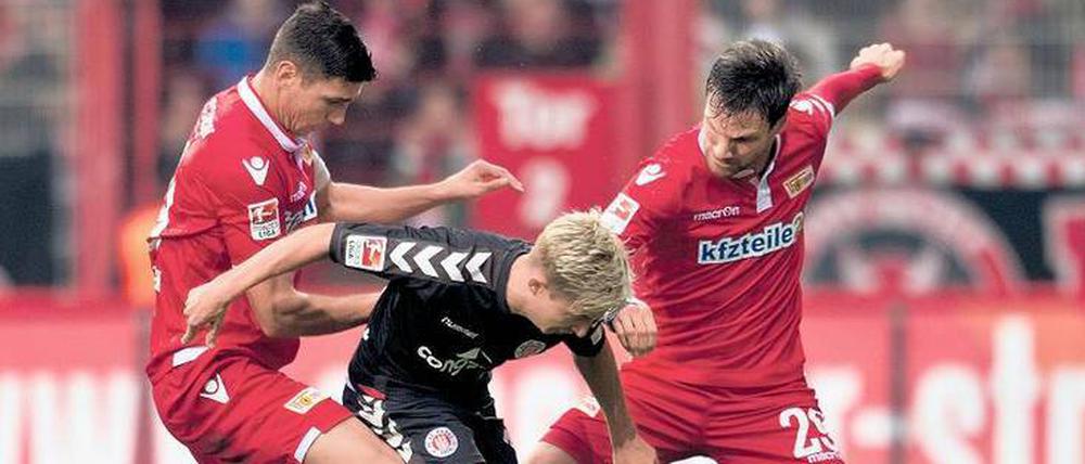 Nimm du ihn, ich hab ihn sicher. Die Unioner Damir Kreilach (l.) und Michael Parensen (r.) beackern St. Paulis Marc Rzatkowski. Nicht immer setzten sich die Köpenicker in den Zweikämpfen durch.