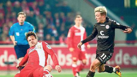 Kampf um Ball und Kult. Am Samstag treffen die beiden Revoluzzer-Klubs 1. FC Union und FC St. Pauli in der Alten Försterei aufeinander. Beide Klubs haben ihr Bestreben, anders zu sein, geschickt vermarktet. Foto: dpa/Mehlis