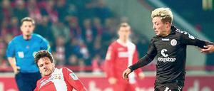 Kampf um Ball und Kult. Am Samstag treffen die beiden Revoluzzer-Klubs 1. FC Union und FC St. Pauli in der Alten Försterei aufeinander. Beide Klubs haben ihr Bestreben, anders zu sein, geschickt vermarktet. Foto: dpa/Mehlis