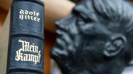"Mein Kampf" neben einer Büste von Adolf Hitler. 