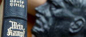 "Mein Kampf" neben einer Büste von Adolf Hitler. 