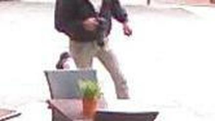 Einer der Täter während des Überfalls. In seiner Hand die Reizgasdose.