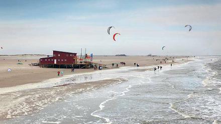 Weiter Strand, Spaziergänger und Kitesurfer in St. Peter-Ording.