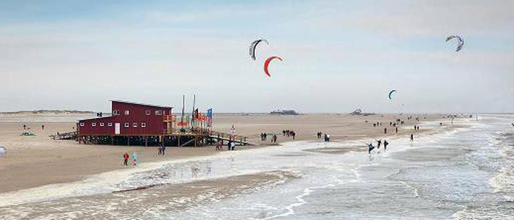 Weiter Strand, Spaziergänger und Kitesurfer in St. Peter-Ording.