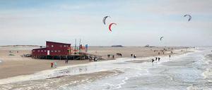 Weiter Strand, Spaziergänger und Kitesurfer in St. Peter-Ording.