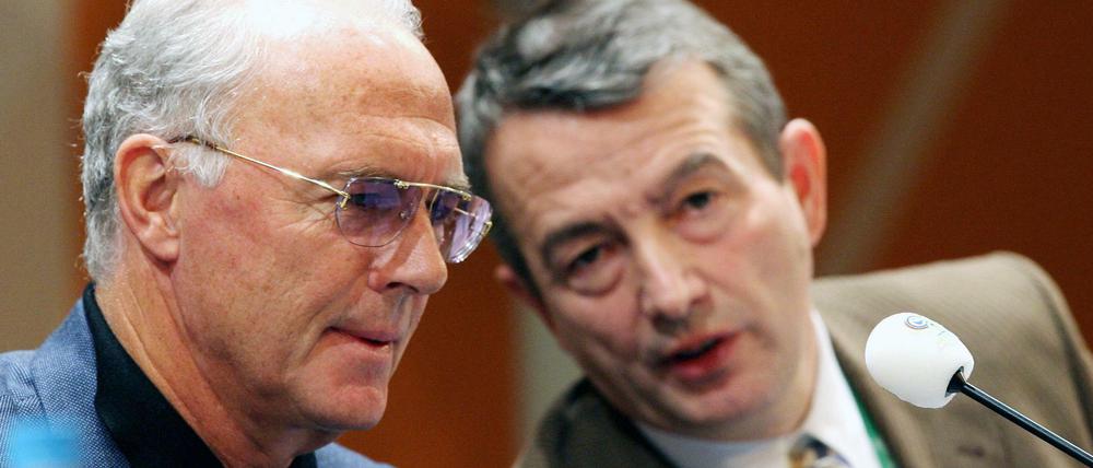 Der Präsident des deutschen FIFA Organisationskomitees, Franz Beckenbauer (l.), spricht am 07.12.2005 mit seinem Vize-Präsidenten, Wolfgang Niersbach, auf einer Pressekonferenz auf der Leipziger Messe. Beide informierten über den Stand der Vorbereitungen zur Endrundenauslosung der Fußball-Weltmeisterschaft 2006 am 09.12.2005 in Leipzig.