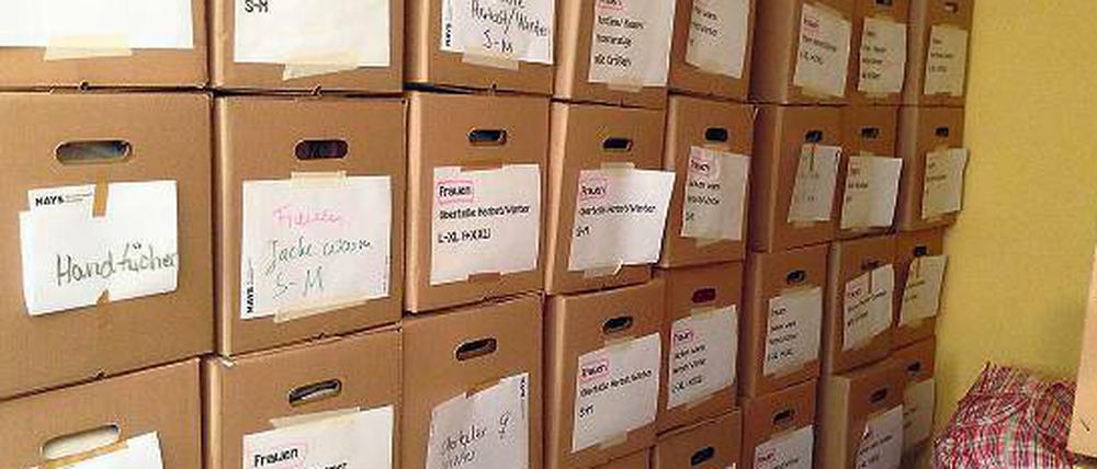 Stapelweise. Die Kleiderspenden der Caritas werden in Kartons sortiert.
