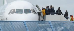 Abgelehnte Asylbewerber steigen in ein Flugzeug.