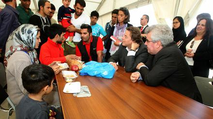 Der Außenminister der Niederlande Bert Koenders (2. von rechts) spricht in einem Zeltlager in Griechenland mit Flüchtlingen.