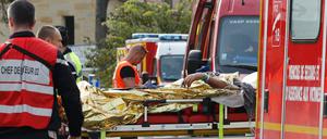 Rettungskräfte transportieren Verletzte ab.