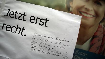 Bürger in Köln machen der schwer verletzten und gerade gewählten neuen Oberbürgermeisterin Henriette Reker an ihren Wahlplakat Mut zum Weitermachen.