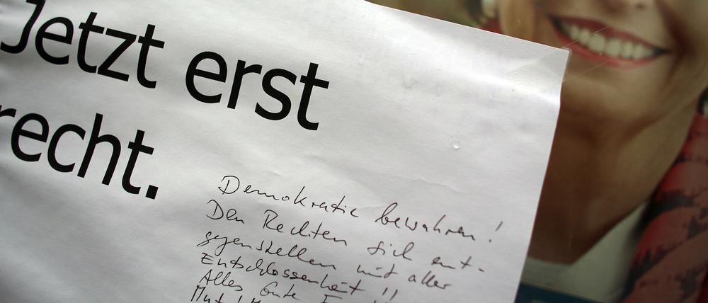 Bürger in Köln machen der schwer verletzten und gerade gewählten neuen Oberbürgermeisterin Henriette Reker an ihren Wahlplakat Mut zum Weitermachen.