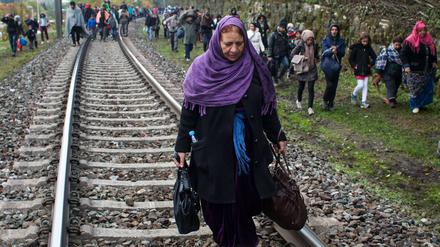 Flüchtlinge gehen an Eisenbahnschienen an der slowenischen Grenze entlang nach Österreich.