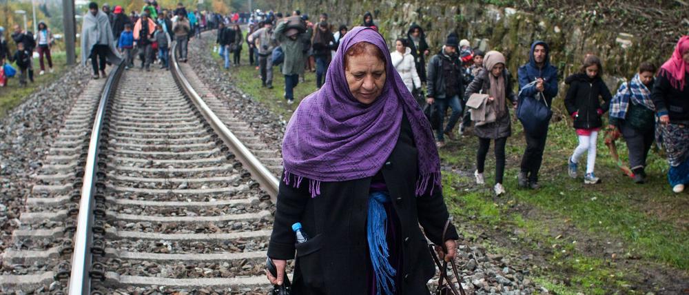 Flüchtlinge gehen an Eisenbahnschienen an der slowenischen Grenze entlang nach Österreich.