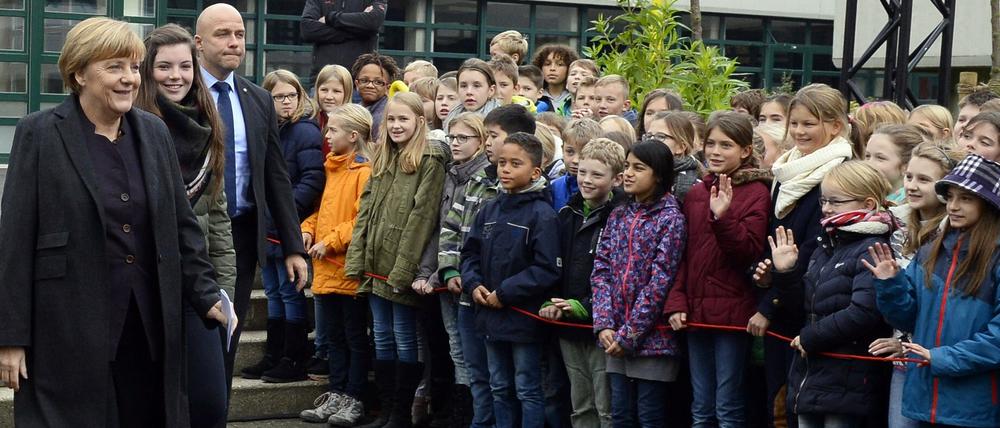 Bundeskanzlerin Angela Merkel wird von Schülerinnen und Schülern des Joseph-König-Gymnasiums im nordrhein-westfälischen Haltern begrüßt.