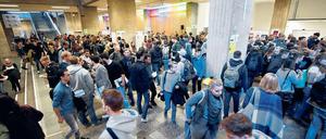 Studierende laufen suchend durch das Foyer eines Universitätsgebäudes.