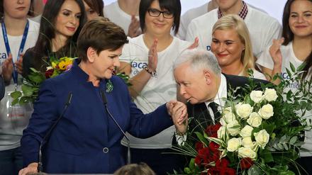 Jaroslaw Kaczynski küsst die Hand der Wahlsiegerin Beata Szydlo.