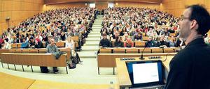 Ein Professor steht vor Studierenden in einem Hörsaal.