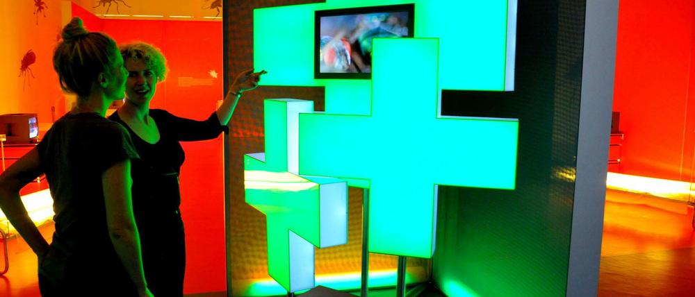 Zwei Frauen stehen vor einer Lichtinstallation in einer Ausstellung.