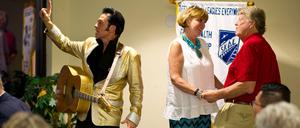 Ein Elvis-Imitator tritt auf der Bühne auf, während John Rada (r) und seine Frau Llana Smith (M) am 27.08.2015 nach ihrer erneuten Hochzeit auf einem Tourismuskongress in Las Vegas (USA) tanzen. Jährlich werden in Vegas nach Angaben der Stadt mehr als 80 000 Ehen geschlossen - das sind im Schnitt 200 pro Tag.