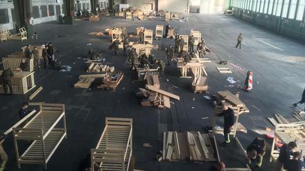 Bundeswehr, Feuerwehr und freiwillige Helfer bauen am Freitagnachmittag gemeinsam Betten im Hangar 3 des Flughafens Tempelhof auf.