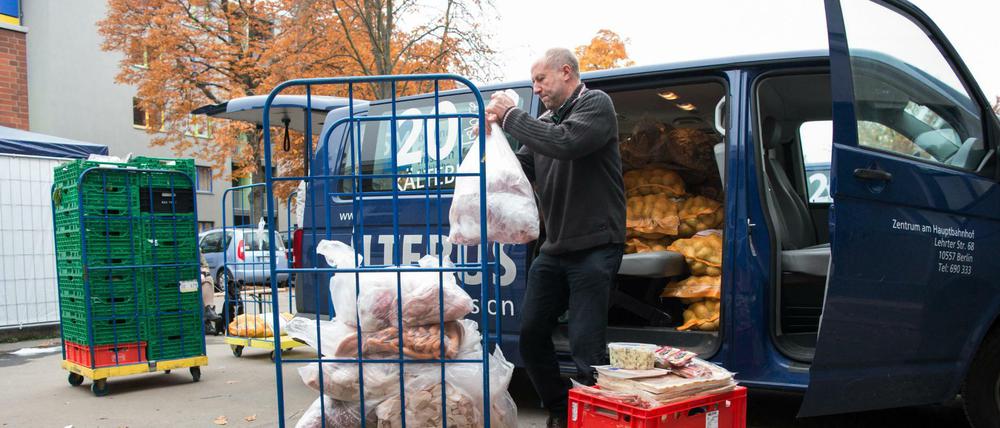 Helfer laden Lebensmittel aus einem Fahrzeug an der Notübernachtungsstelle der Berliner Stadtmission in der Nähe des Hauptbahnhofs in Berlin.