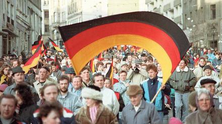 Flagge der Einheit. Anfang 1990 demonstrierten, wie hier im sächsischen Plauen, die DDR-Bürger für die Wiedervereinigung. 