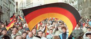 Flagge der Einheit. Anfang 1990 demonstrierten, wie hier im sächsischen Plauen, die DDR-Bürger für die Wiedervereinigung.