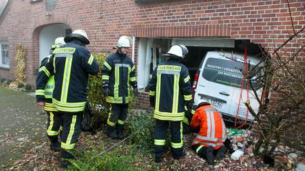 Feuerwehrleute bergen am Montag in Holtum-Geest (Niedersachsen) einen Kleinbus, der bei einem Unfall die Außenwand eines Wohngebäudes durchbrochen hat und in der Küche landete. Nach Angaben eines Polizeisprechers wurden der Fahrer und Beifahrer leicht verletzt. Die Bewohner waren beim Unfall nicht in der Küche.